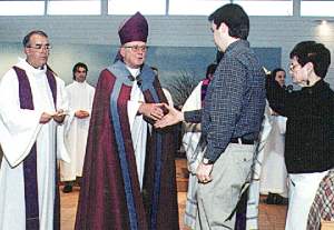 photo of Bishop Bullock and Fr. Richel greeting candidate and sponsor