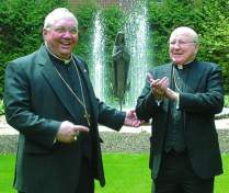photo of Bishop Bullock, right, applauding after introducing Bishop Morlino