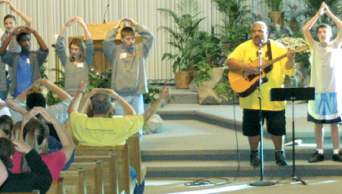 photo of Jesse Manibusan singing with high school youth