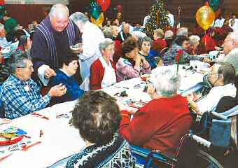 photo of Bishop Morlino distributing Communion during Apostolate to the Handicapped Mass and Christmas celebration