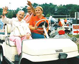 photo of Deloris Darier of Madison and Paul Wichmann of Madison waving as Lotta Hernesnemi of the Tommy Bartlett staff transports them