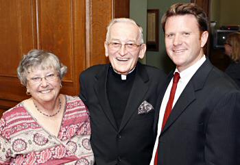 photo of Monsignor Thomas F. Campion, center, standing with State Assembly Representatives Barbara Gronemus and Brett Davis in the assembly chambers at the Wisconsin State Capitol