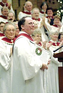 photo of Patrick Gorman, director of the Madison Diocesan Choir, being presented with a choral anthem based on the Beatitudes, in honor of his 15 years as director